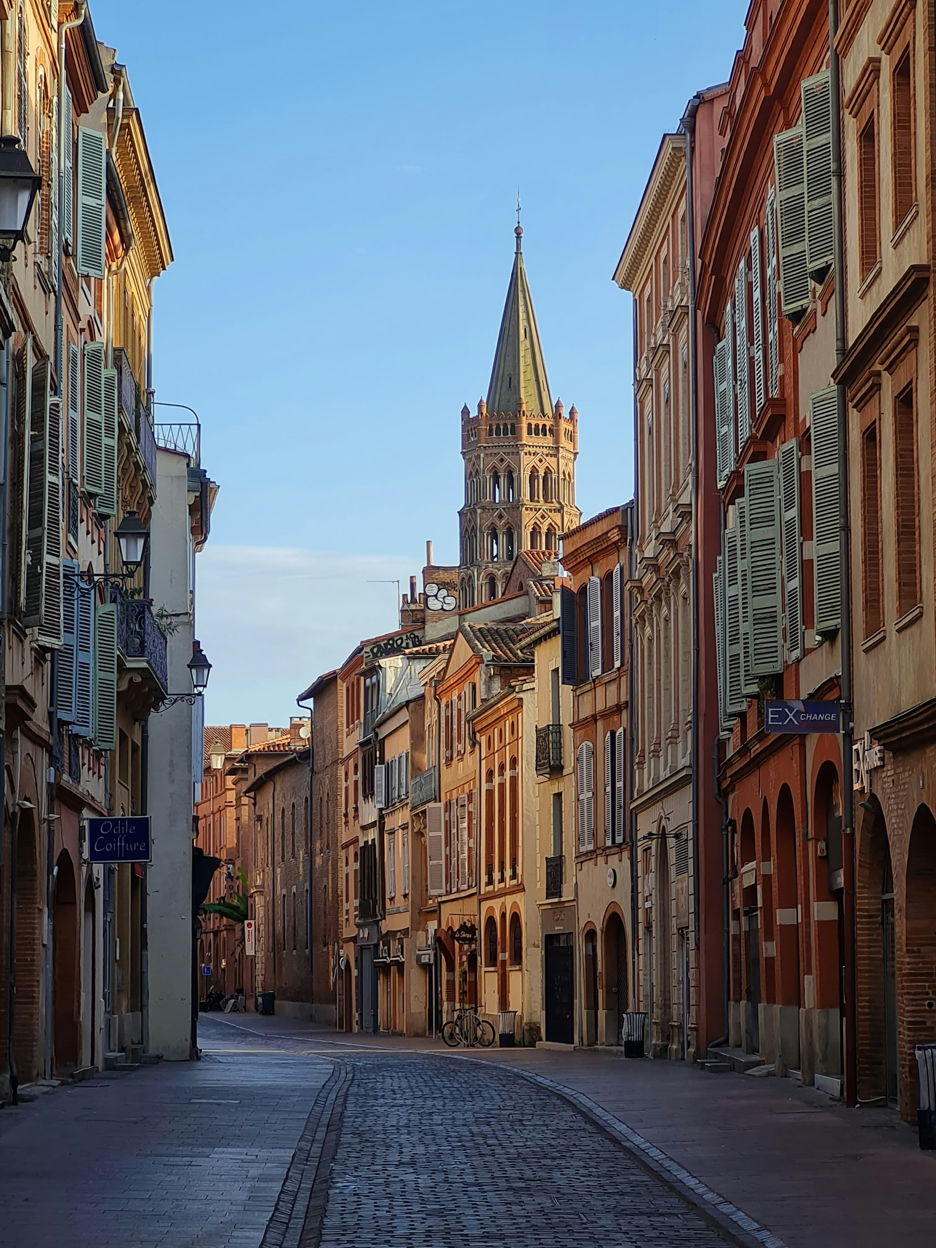 Une rue de Toulouse en brique, avec un clocher
